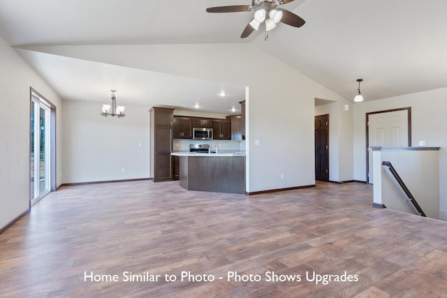 unfurnished living room with wood-type flooring, vaulted ceiling, and ceiling fan with notable chandelier