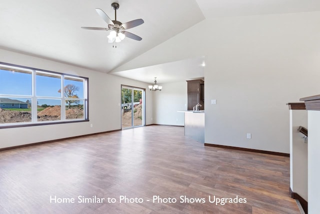 unfurnished living room featuring high vaulted ceiling, ceiling fan with notable chandelier, and dark hardwood / wood-style flooring