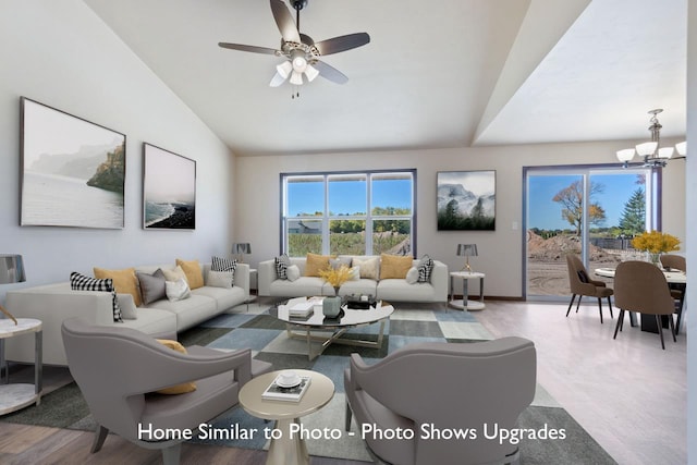 living room with vaulted ceiling, ceiling fan with notable chandelier, and hardwood / wood-style floors