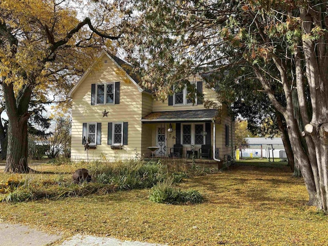 view of front of property with a porch and a front lawn