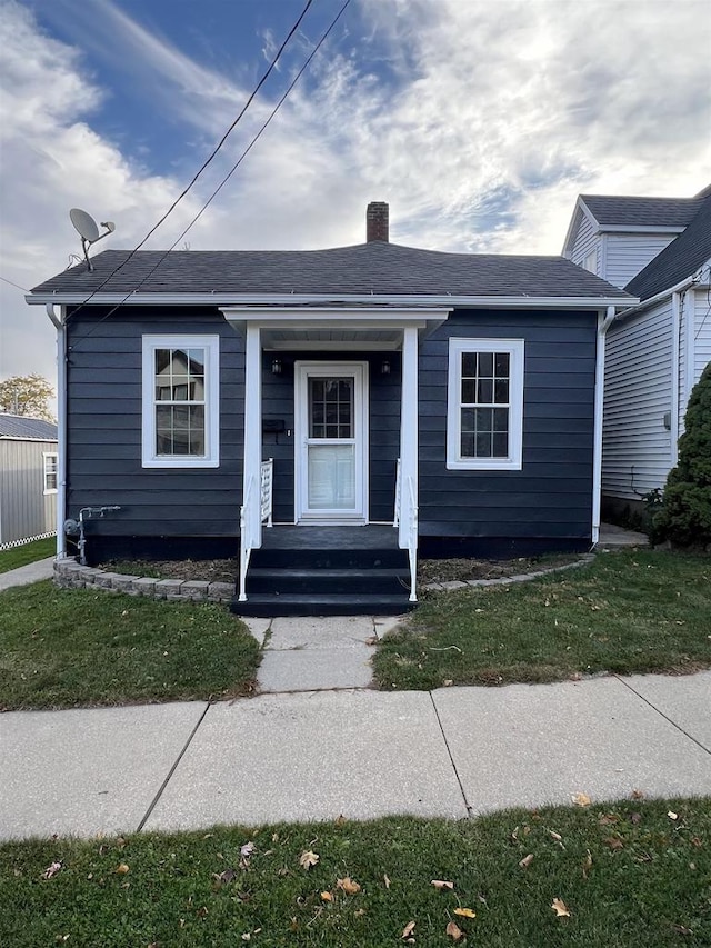 view of front of property with covered porch and a front yard