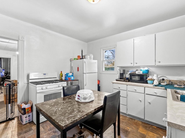 kitchen featuring white cabinets and white appliances