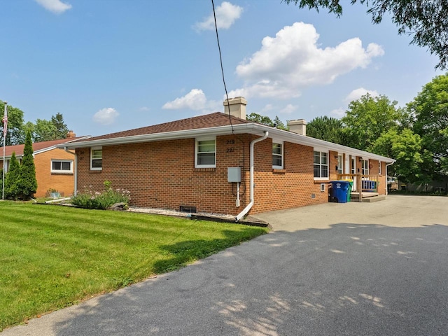 view of side of home with a yard