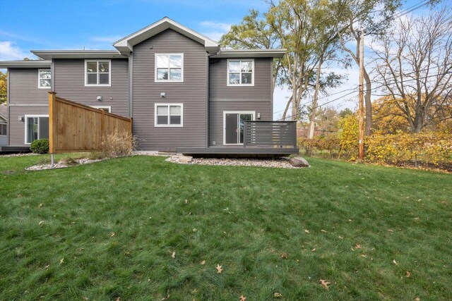 rear view of property with a deck and a lawn