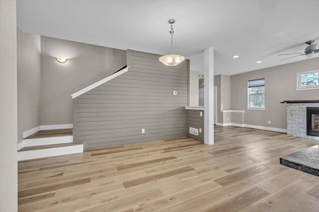 unfurnished living room featuring ceiling fan and hardwood / wood-style floors