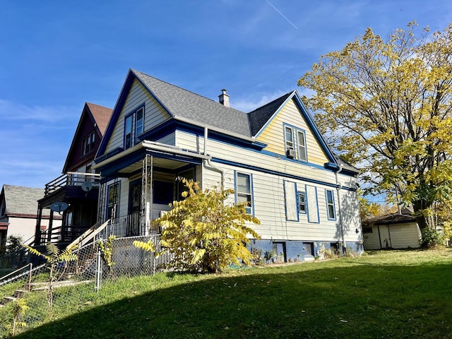 view of side of home with a yard and a shed