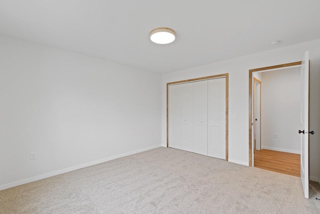 unfurnished bedroom featuring light carpet and a closet