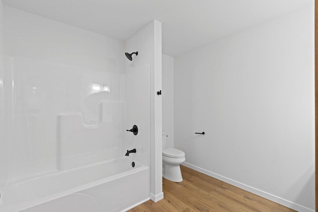 bathroom with toilet, hardwood / wood-style flooring, and tub / shower combination