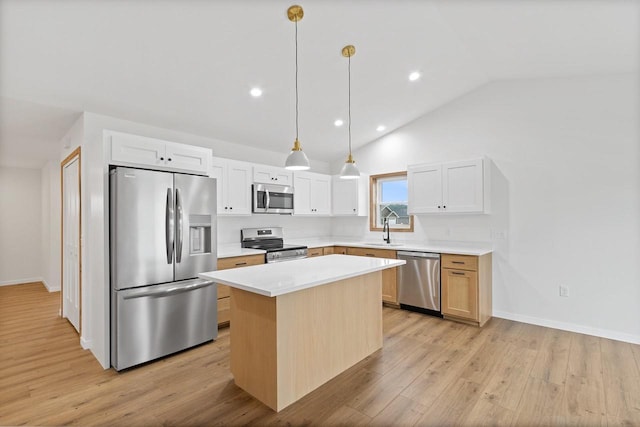 kitchen featuring appliances with stainless steel finishes, lofted ceiling, white cabinetry, and a kitchen island