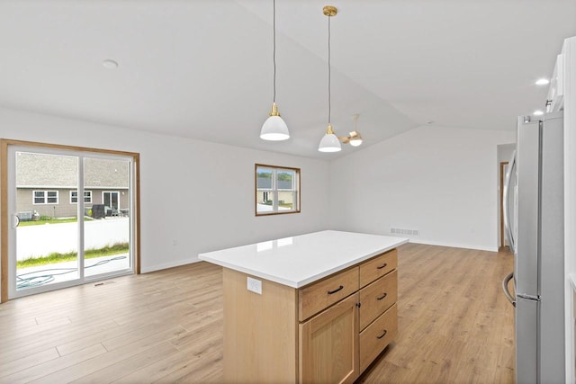 kitchen with light hardwood / wood-style flooring, hanging light fixtures, vaulted ceiling, a center island, and stainless steel refrigerator