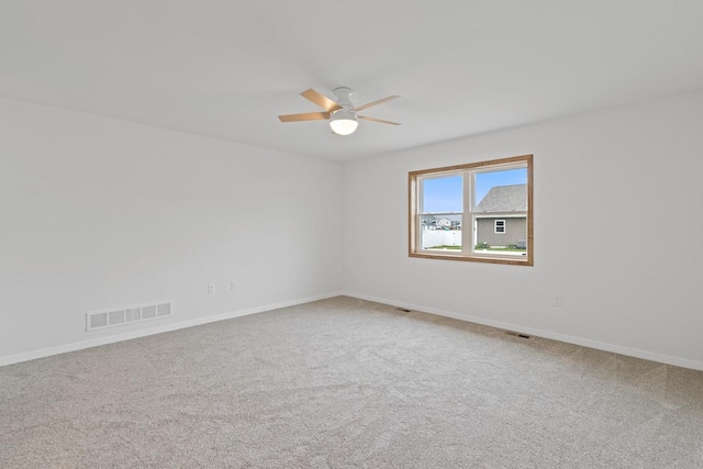 carpeted spare room with ceiling fan