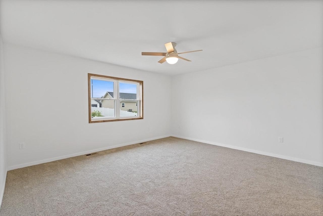 carpeted spare room with ceiling fan