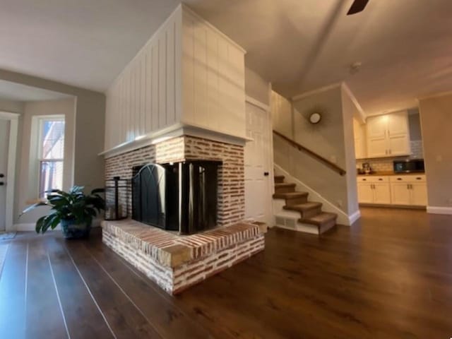 living room with lofted ceiling, dark wood-type flooring, and a brick fireplace