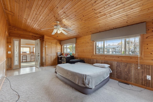 bedroom featuring ceiling fan, wood walls, wooden ceiling, and lofted ceiling