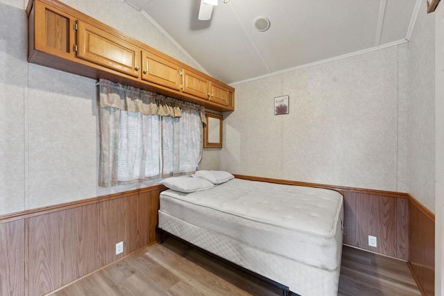 bedroom with light hardwood / wood-style flooring, lofted ceiling, ornamental molding, and ceiling fan