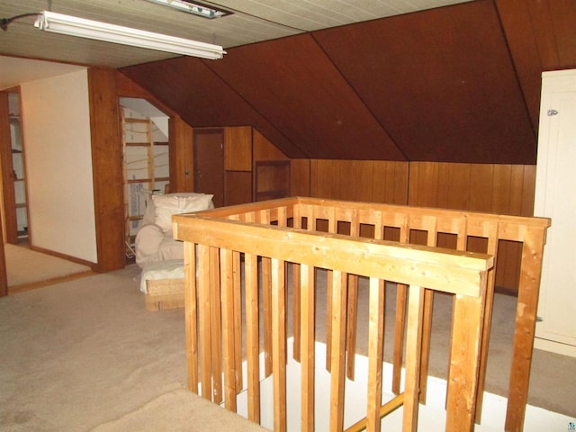 interior space with carpet flooring, lofted ceiling, and wooden walls