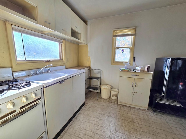 kitchen with sink, white cabinetry, and white gas range oven