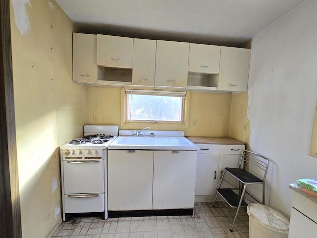 kitchen featuring sink, white cabinets, and gas range gas stove