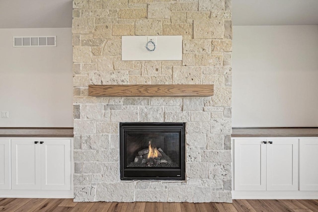 details with a stone fireplace and hardwood / wood-style flooring