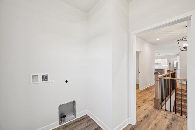 laundry area with light hardwood / wood-style floors, hookup for an electric dryer, a chandelier, and washer hookup