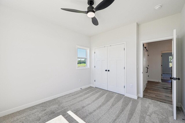 unfurnished bedroom featuring light colored carpet, a closet, and ceiling fan