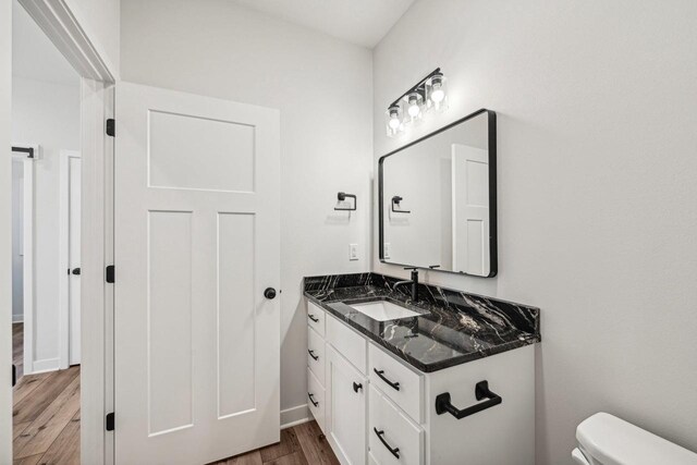 bathroom featuring vanity, toilet, and wood-type flooring