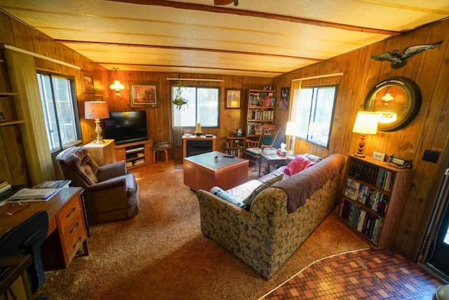 living room featuring vaulted ceiling, dark colored carpet, and a healthy amount of sunlight