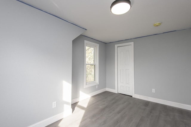 spare room with dark wood-type flooring