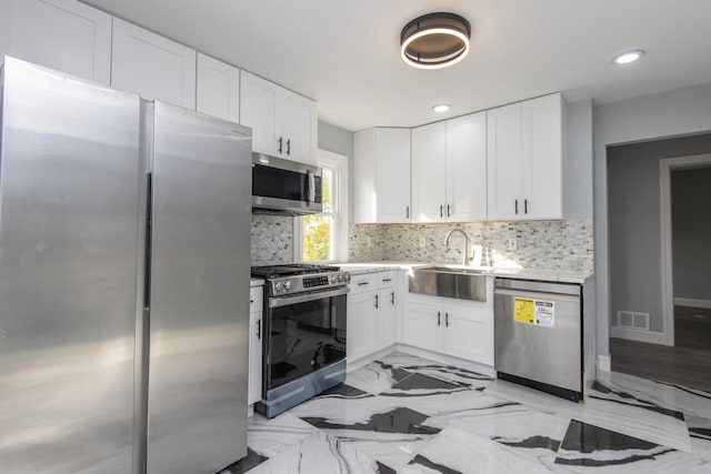 kitchen with sink, white cabinets, stainless steel appliances, and backsplash