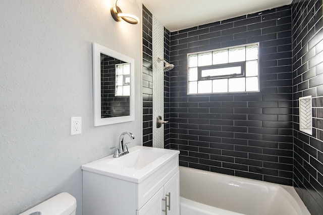 full bathroom featuring toilet, tiled shower / bath combo, and vanity