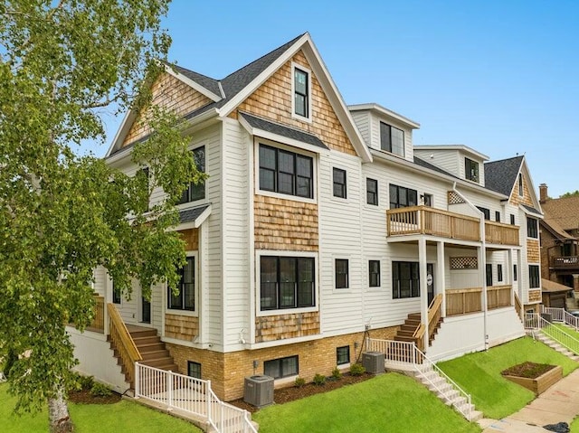 rear view of house featuring a balcony and a lawn