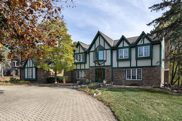 english style home featuring a front yard