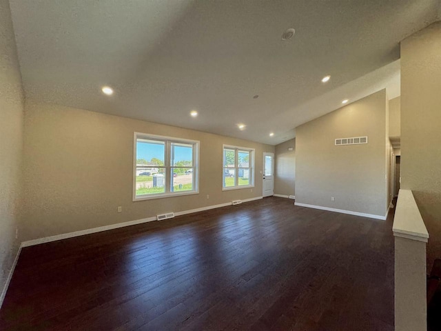 unfurnished room featuring lofted ceiling and dark hardwood / wood-style flooring