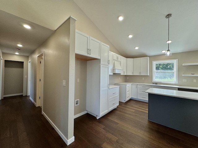 kitchen featuring white cabinetry, dark wood-type flooring, vaulted ceiling, and hanging light fixtures