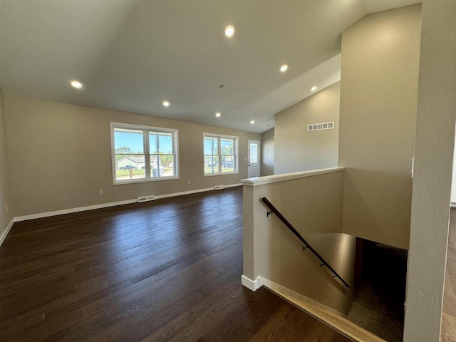 interior space with dark wood-type flooring and vaulted ceiling