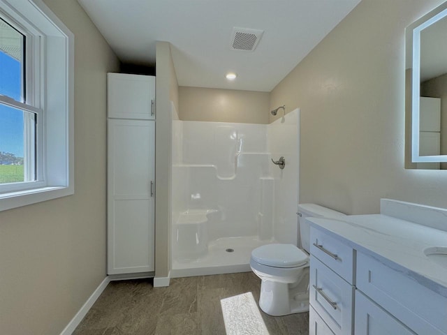 bathroom with vanity, toilet, and a shower