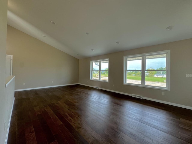 unfurnished room with vaulted ceiling and dark hardwood / wood-style flooring