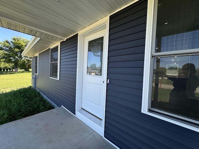 view of exterior entry featuring a yard