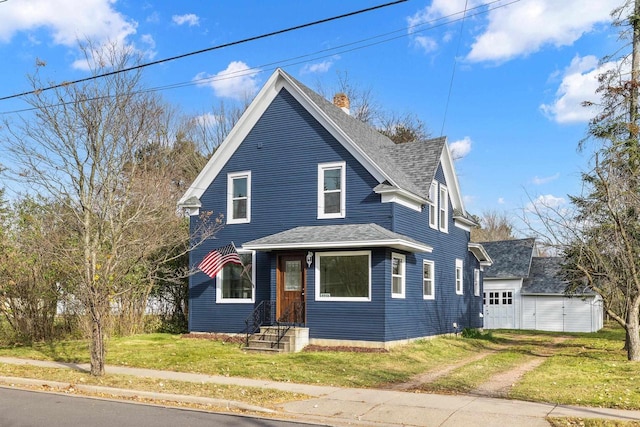 view of front facade featuring a front lawn, an outbuilding, and a garage