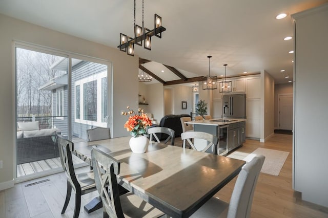 dining space featuring light hardwood / wood-style flooring, lofted ceiling with beams, and beverage cooler