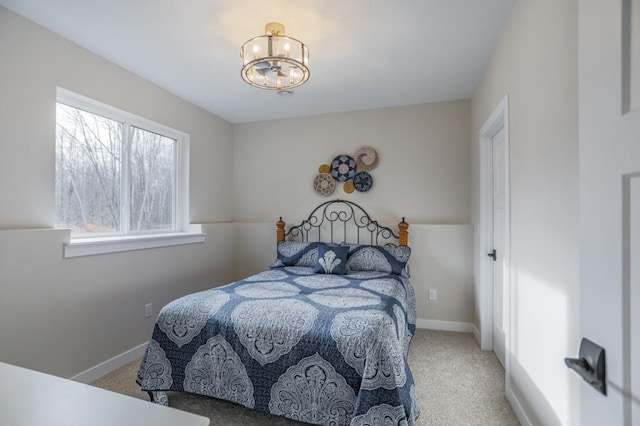 carpeted bedroom featuring multiple windows and a notable chandelier