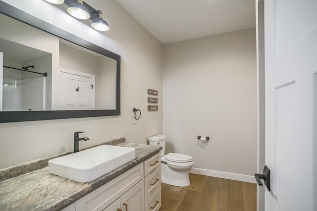 bathroom featuring vanity, toilet, walk in shower, and wood-type flooring