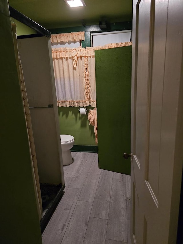 bathroom with toilet and hardwood / wood-style floors