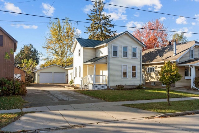 view of front property with a porch, a front yard, an outbuilding, and a garage