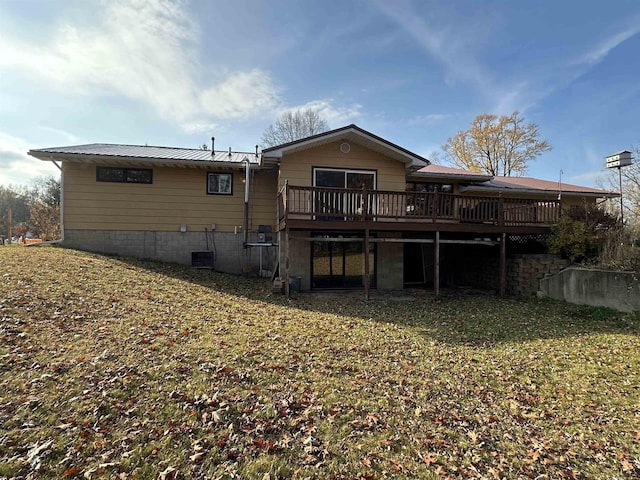 rear view of property featuring a lawn and a wooden deck