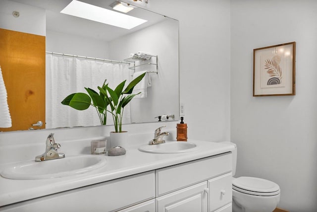 bathroom with vanity, a shower with shower curtain, toilet, and a skylight