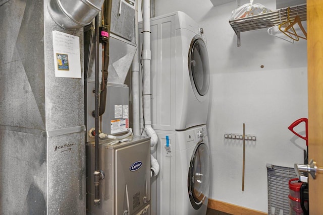 laundry area featuring stacked washer / dryer and heating unit