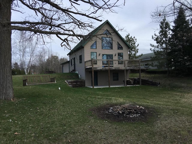 rear view of property featuring a wooden deck and a lawn