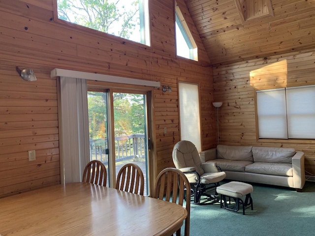 dining space with wooden walls, high vaulted ceiling, plenty of natural light, and hardwood / wood-style floors