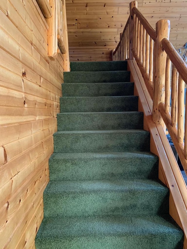 staircase featuring wood ceiling and wood walls